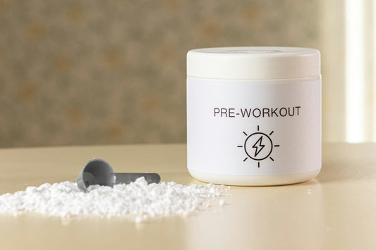 A container of pre-workout sits on a counter with a scoop and spilled powder